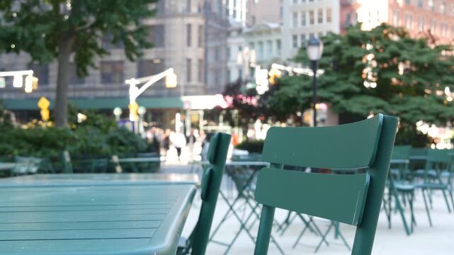Fifth 5 avenue and Broadway street crossroad, Manhattan Midtown, New York City, United States. Defocused people pedestrians, chairs and tables for picnic in Madison Square Park, Flatiron District .