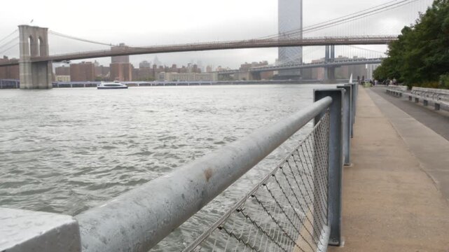 Brooklyn Bridge, Manhattan Bridge from Brooklyn Bridge park, New York City Dumbo, United States. American architecture, famous tourist landmark. Waterfront promenade, riverside esplanade perspective.