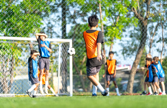 Back of one player action of penalty shoot-out with protect by the opposite players in front of the goal of soccer in the field