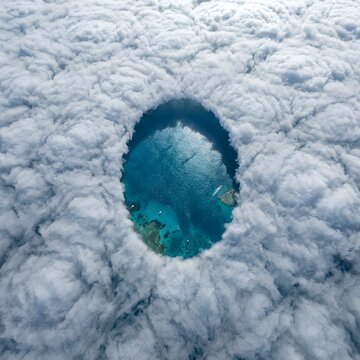Stratocumulus Cloud Break Forming a Perfect Oval Blue Hole Above the Subtropical Ocean