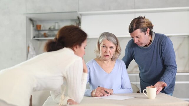 Man and woman help elderly mother make will and fill out document correctly. Family advice, help and support