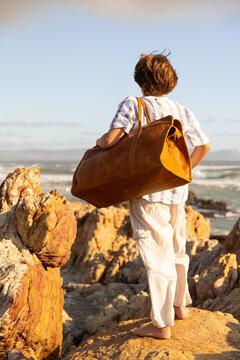 12 year old boy exploring rocky coastline of Hermanus, South Africa