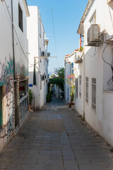 Fototapeta premium Bodrum, Turkey. Narrow cobblestone street descending toward the Aegean Sea, lined with whitewashed houses and traditional architecture, with the blue sea visible at the bottom.