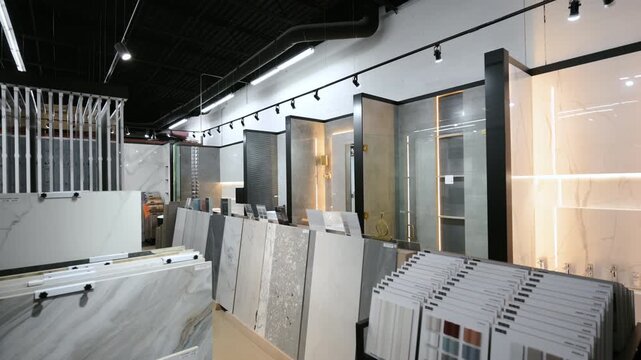 Element of Modern tile showroom interior with large ceramic and porcelain slabs displayed in vertical racks. Wide view
