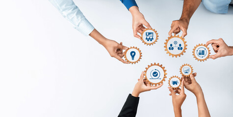 A diverse group of hands interacts with gears that symbolize collaboration and innovation in...