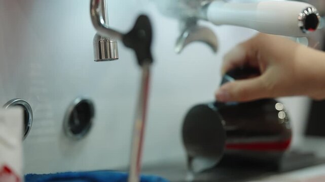 Close-up sequence of a barista operating a commercial espresso machine, aligning the portafilter and steam wand while preparing espresso and frothing milk on a stainless workspace