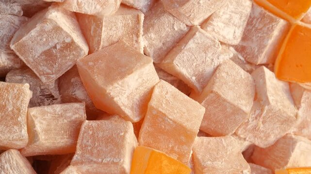 Close up of delightful turkish delight cubes covered in powdered sugar in slow motion.