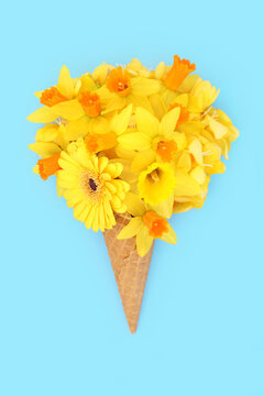 Gerbera narcissus freesia flower ice cream cone on blue background. Fantasy food art spring floral bouquet arrangement for gift, greeting card or logo.