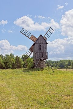 Typical Estonian post windmill standing in a lush green field in summer with clouds in the sky, Muhu, Estonia, Europe.
