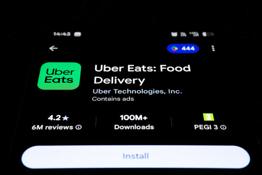 Uber Eats application in Google Play Store on smartphone screen, mobile food delivery service interface on dark background, ordering meals online, app icon and install button on cell phone.