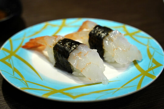 Delicious Amaebi nigiri sushi served on a rotating conveyor belt sushi bar.