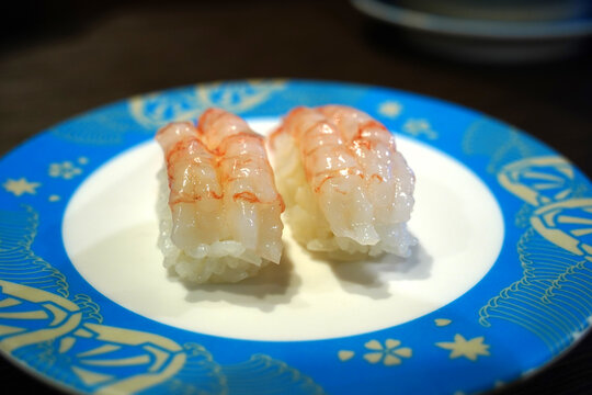Delicious Amaebi nigiri sushi served on a rotating conveyor belt sushi bar.