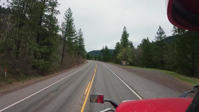 Big rig truck POV driving on a curved forest mountain road, freight logistics