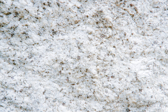 Close up of white granite surface texture. Intrusive igneous rock