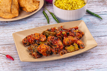 Plate of spicy glazed breaded prawn stir-fry with bell peppers and a side of yellow rice
