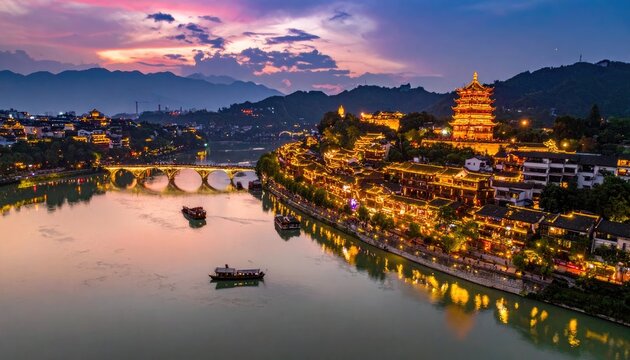 A stunning panoramic view of the ancient town of Yangshuo, China, illuminated at dusk with a picturesque river, traditional architecture, and a vibrant sunset sky.
