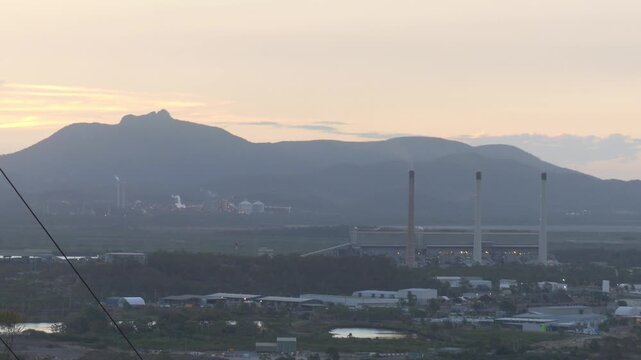 Gladstone Australian power station smoke stacks and mountains at sunset 4k