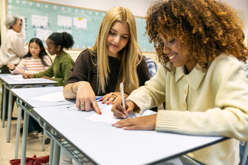 Happy students working on assignments, with one student helping another. Diverse group engaged in education and teamwork