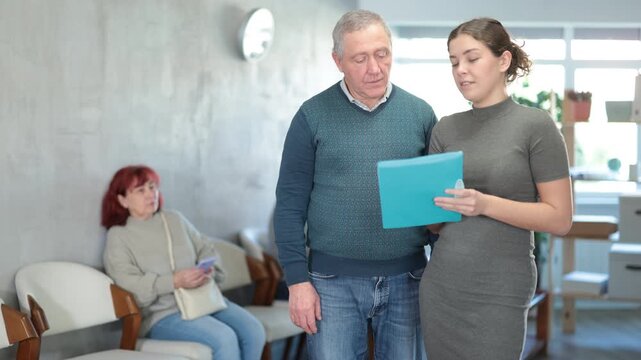 Secretary or social worker talk with man in reception area. High quality 4k footage