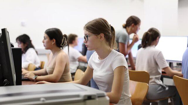 Clever female teenager wearing glasses and solving tasks of computer science in the auditory