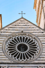 Obraz premium Genoa Cathedral facade with distinctive black and white marble stripes ornate arches and large rose window under clear blue sky, Genoa, Italy 