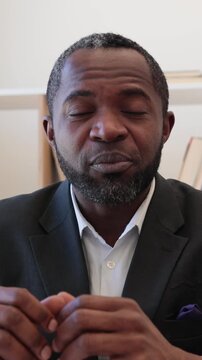 A thoughtful African American man in a suit speaks with conviction, his gaze directed away from the camera