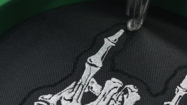 Extreme Macro Close Up Industrial Embroidery Machine Single Needle Rapid Stitching White Satin Border on Black Fabric Skeleton Hand Patch Design Handheld Slow Motion Authentic Production