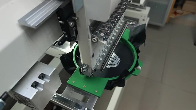 Detailed Macro Close Up: Industrial Multi-Needle Embroidery Machine Head Moves Backward to Reveal Intricate White Pattern Stitched on Black Fabric. Handheld Slow Motion Footage