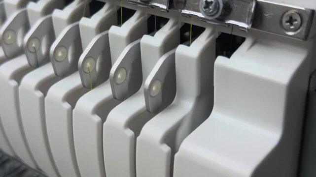 Macro Close Up of Industrial Multi-Needle Embroidery Machine Metallic Take-up Levers Moving Synchronously in Garment Factory Workshop Handheld Slow Motion Authentic Technical Production Scene