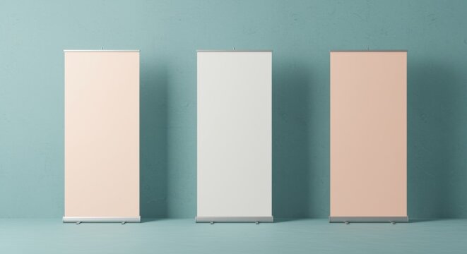 Three blank pull-up banners standing in a row against a teal wall for marketing display mockups and trade show exhibition equipment background with copy space