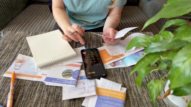 Woman checking utility receipts and bills for home budget planning