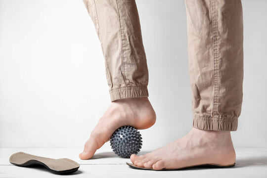 Side view of foot correction with orthopedic insole and massage ball