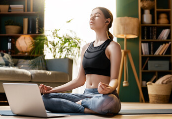 Young Woman Meditating at Home with Laptop ? Mindfulness and Wellness Lifestyle