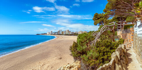 Panoramic view of Platja d'Aro beach and the coastal path Camino de Ronda of the Costa Brava, Spain, on a sunny day.