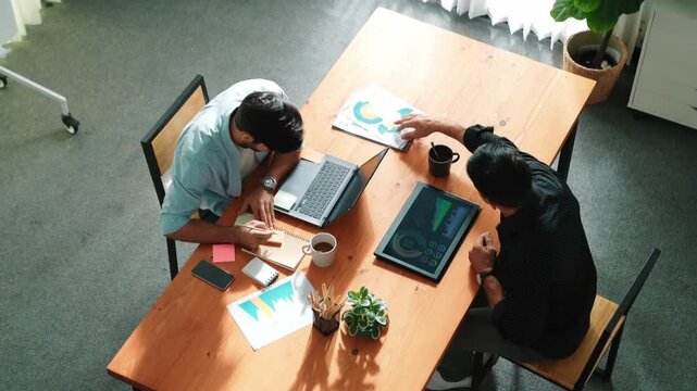 Top view of business team working together to analysis data by using laptop on meeting table. Diverse creative people discussing and brainstorming plan while looking at financial graph. Convocation.