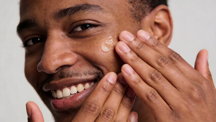 Fototapeta premium Man applying skincare product to face