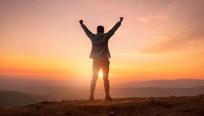 Fototapeta premium Man celebrating success on mountain peak at sunset with arms raised.