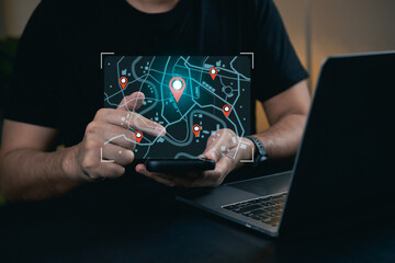 Man Using Tablet to Navigate Map with Location Pins and Laptop Next to Him in Modern Workspace Setting for Technology and Communication Themes