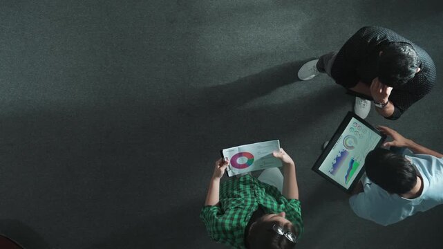 Top down view of businessman thinking about marketing plan or making decision to invest in startup project while smart professional business team sharing idea by using tablet at meeting. Convocation.