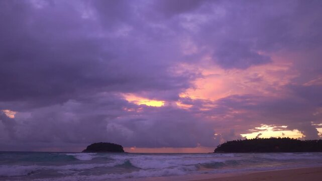 smooth waves hit on the beach at puple sunset.
purple clouds cover the ocean during colorful cloud in sunset at Kata beach Phuket.
video 4K. Scene of pink light in the sky background.