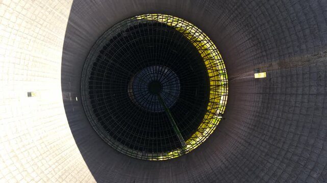 Interior abandoned nuclear cooling tower with metal grid and central shaft, industrial decay details. Environmental pollution and ecology concerns concept inside decommissioned power plant. Circular