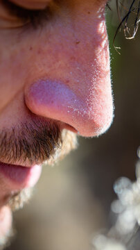 Breathwork exercise outdoor nature focus on male nose and mustache with sunlight highlighting skin texture and facial hair detail creating calm natural atmosphere