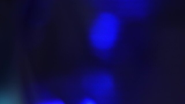 Colorful lights shine in different frames with varying colors and patterns in a simple display during evening hours