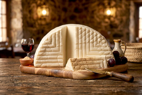 Food featuring local Majorero cheese, gofio, and mojo sauce on a cutting board. The cheese is made with Majorero goat's milk from Fuerteventura, Spain. Rustic cuisine. Image created by IA