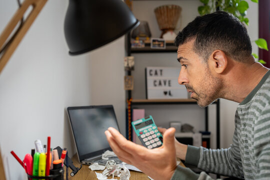 Entrepreneur calculating debt during financial crisis at home office