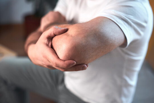Man with elbow pain at home.