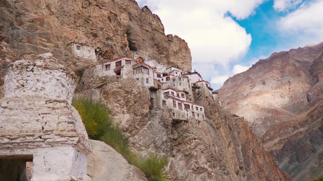 View of the Phugtal monastery built inside the mountain cave at Zanskar, Ladakh, India. Remote monastery in India. Clouds in sky during summer day. Travel and holidays concept.