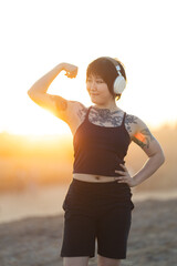Obraz premium Young woman flexing arm demonstrating strength and confidence