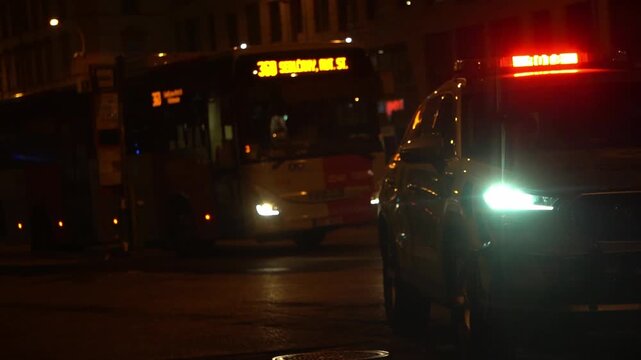 Police patrol car with active emergency lightbar on an urban street. Blurred city traffic in the background. Concept of law enforcement, public safety, and security monitoring.