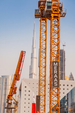 11 January 2026, Dubai, UAE: Construction cranes operating and building a modern cityscape. Burj Khalifa rising prominently against a clear sky, symbolizing urban development